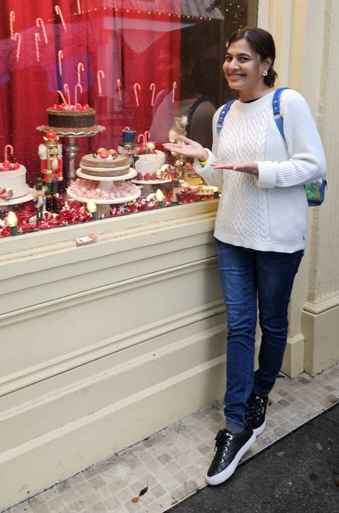 women standing in front of a window showing baked goods