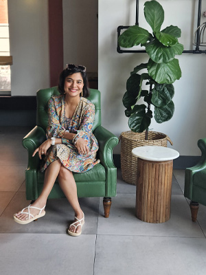 Professional Headshot of a women sitting in a green chair in an office